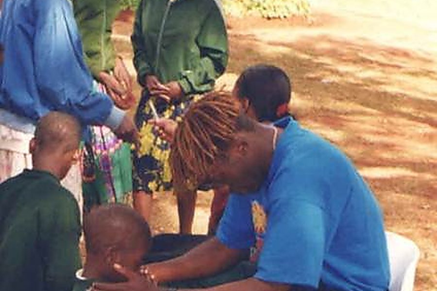 A caregiver praying with one of the Mumvuri Project orphans